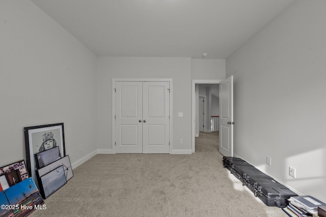 bedroom featuring a closet, baseboards, and carpet flooring