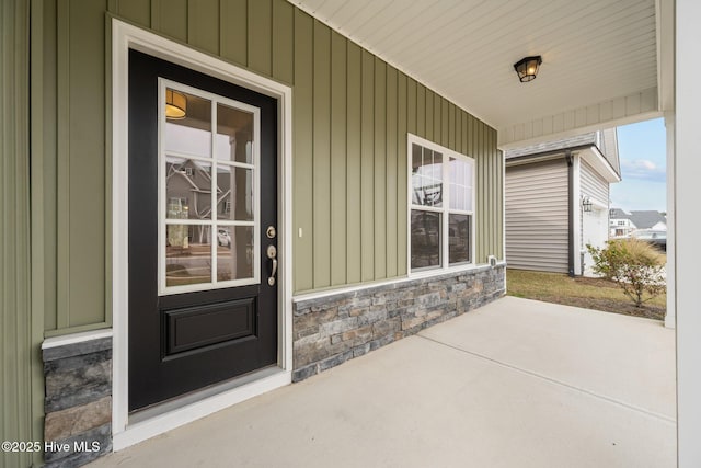 entrance to property with board and batten siding and stone siding