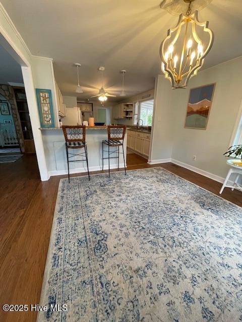 dining room featuring baseboards, dark wood-style flooring, and a notable chandelier