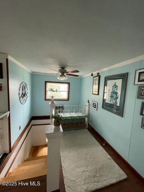 sitting room with wood finished floors, a water view, and baseboards
