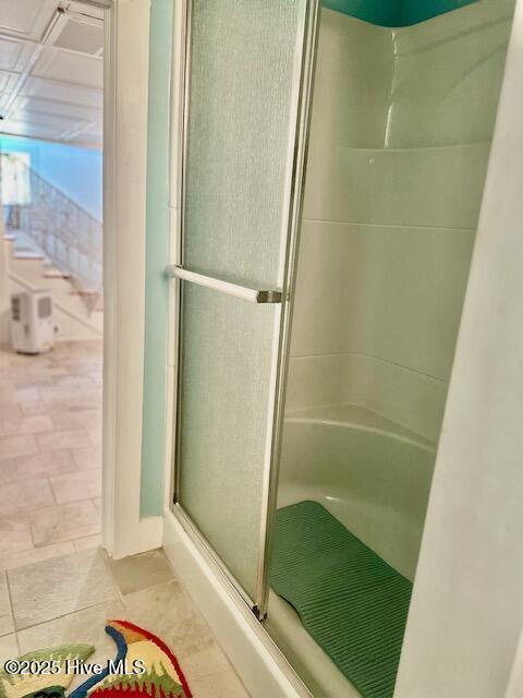 bathroom with toilet, vanity, a stall shower, tile patterned flooring, and baseboards