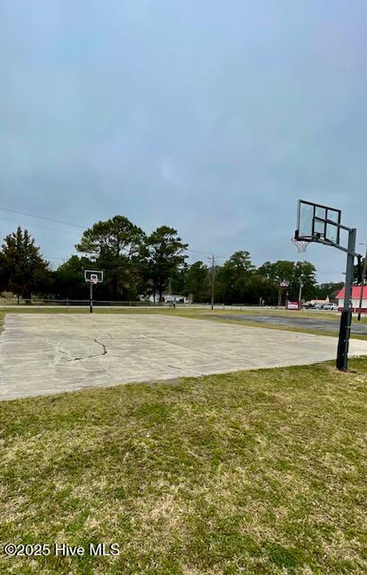 view of basketball court featuring community basketball court and a lawn
