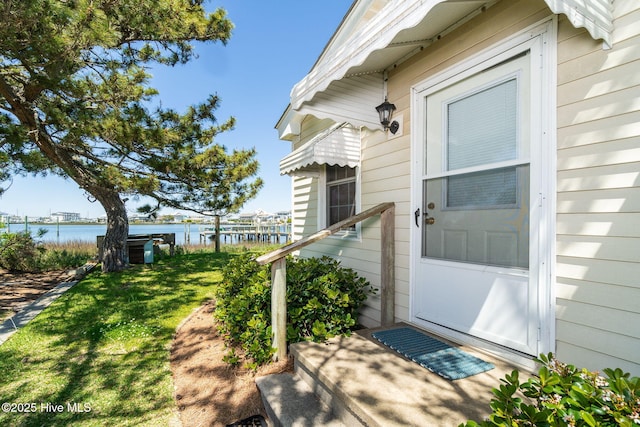 entrance to property with a lawn and a water view