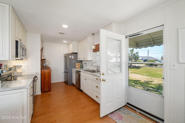 kitchen featuring a healthy amount of sunlight, stainless steel appliances, light countertops, and a sink