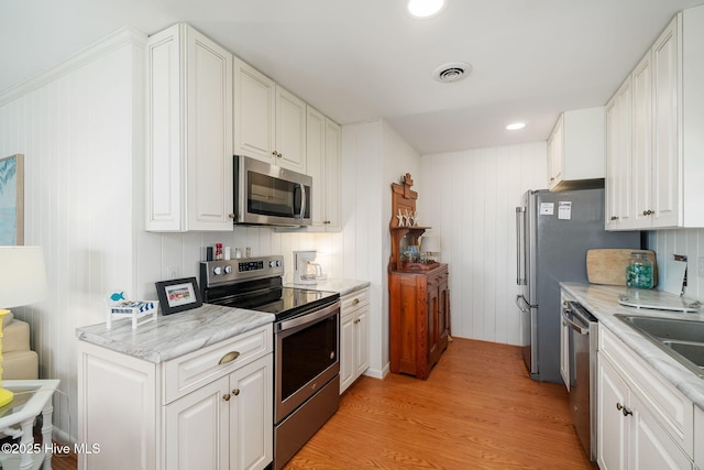 kitchen featuring white cabinetry, light wood-style flooring, visible vents, and appliances with stainless steel finishes