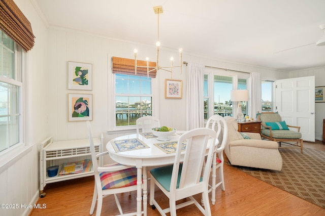 dining space with a chandelier, crown molding, and wood finished floors