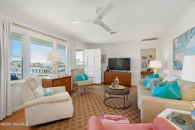 living room featuring visible vents, wood finished floors, ceiling fan, and crown molding