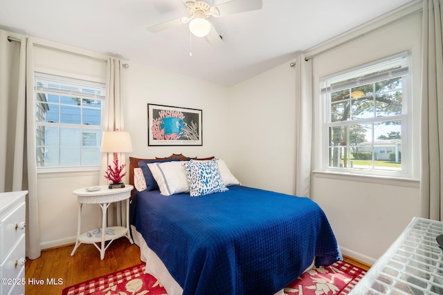 bedroom featuring a ceiling fan, baseboards, and wood finished floors