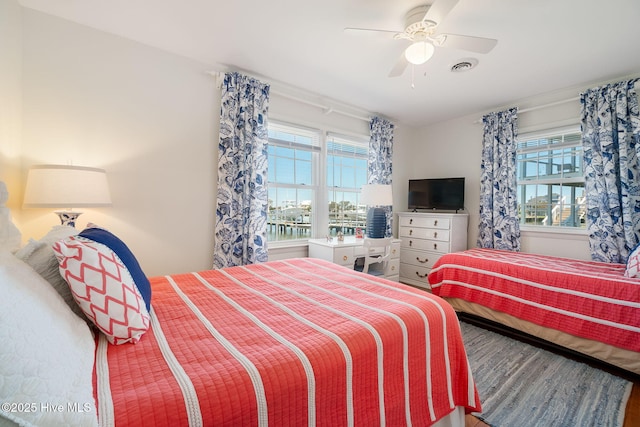 bedroom with visible vents, a ceiling fan, and wood finished floors