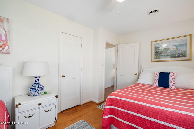 bedroom featuring visible vents, baseboards, light wood-type flooring, and a ceiling fan