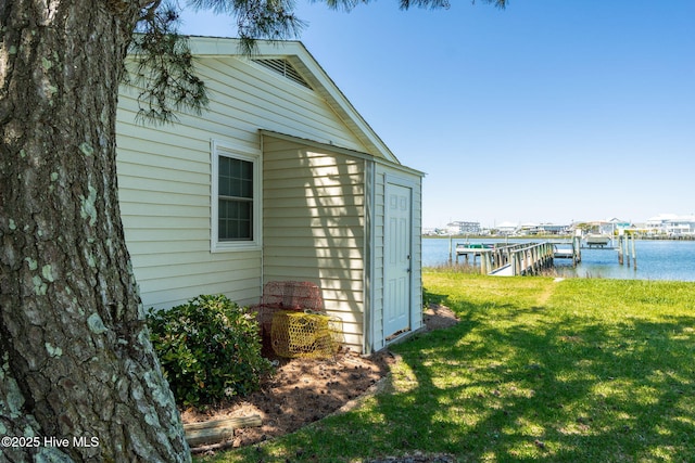 view of property exterior with boat lift, a lawn, a boat dock, and a water view