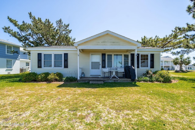 view of front of house featuring a front yard, a porch, and central AC