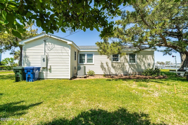 rear view of house with a yard and central AC unit