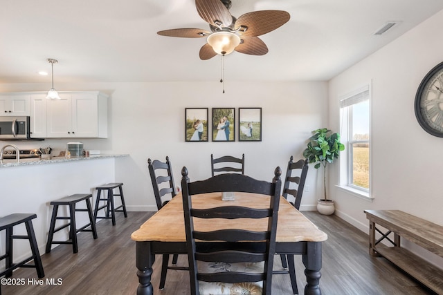 dining area featuring dark wood finished floors, baseboards, and visible vents