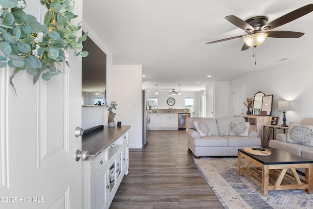 living room with visible vents, recessed lighting, dark wood-type flooring, and a ceiling fan