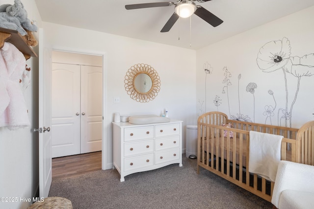 bedroom featuring a crib, ceiling fan, carpet floors, and a sink