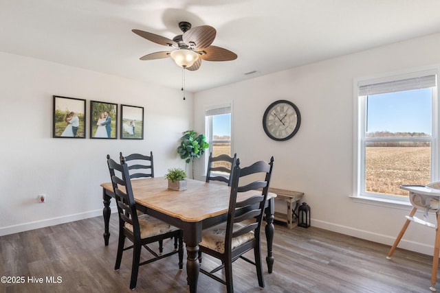 dining room featuring visible vents, ceiling fan, baseboards, and wood finished floors