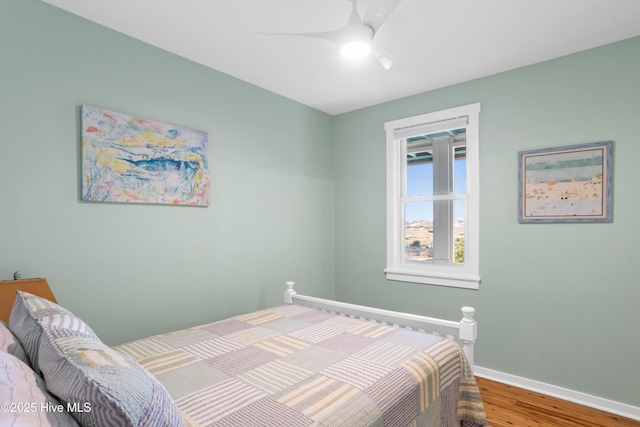 bedroom with ceiling fan, baseboards, and wood finished floors