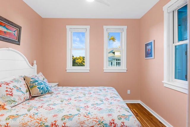 bedroom featuring baseboards and dark wood-style flooring