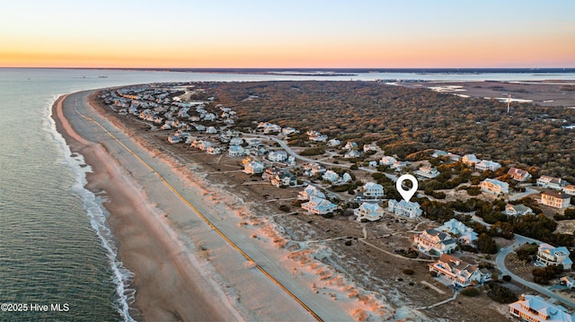 birds eye view of property featuring a beach view and a water view