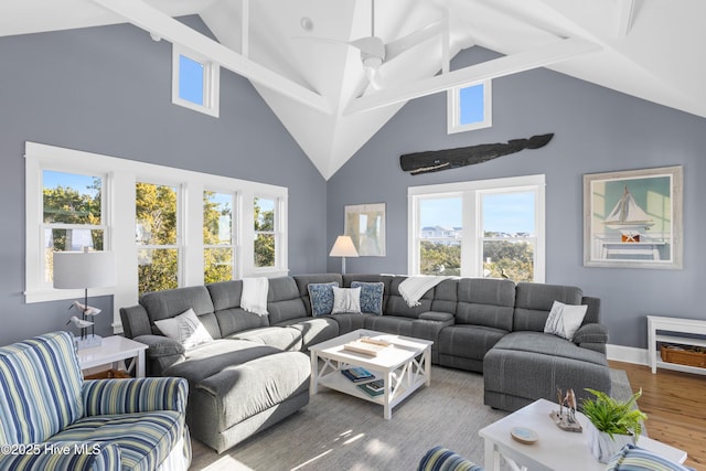 living area featuring high vaulted ceiling, baseboards, ceiling fan, and wood finished floors