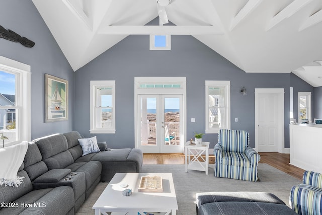 living area with french doors, lofted ceiling with beams, and wood finished floors