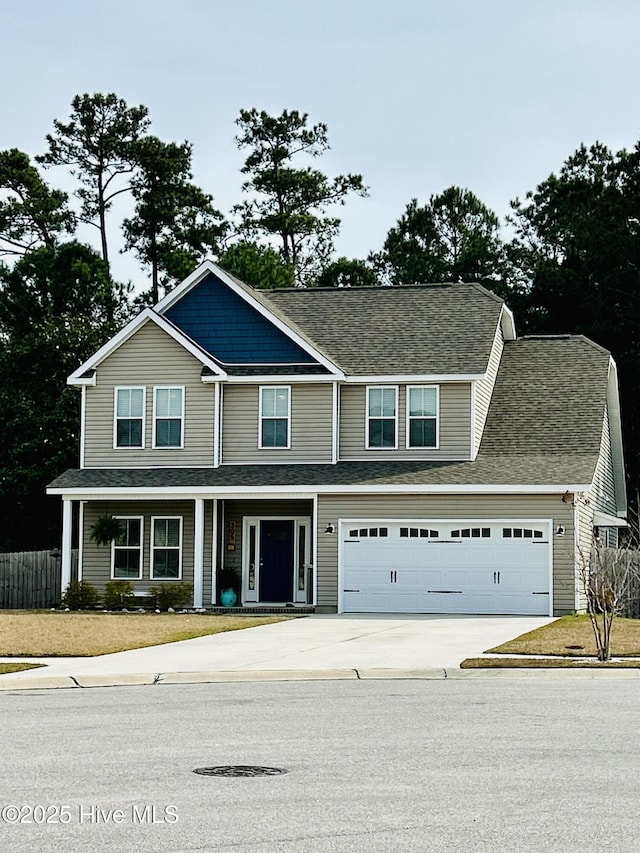 view of front facade with a garage, a porch, driveway, and fence