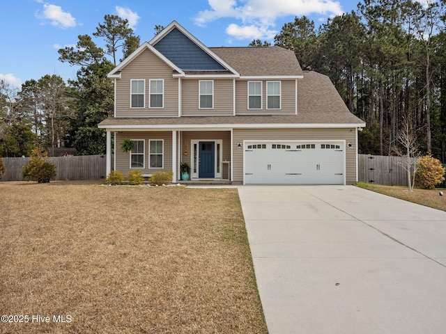 view of front of home with a front yard, fence, a garage, and driveway