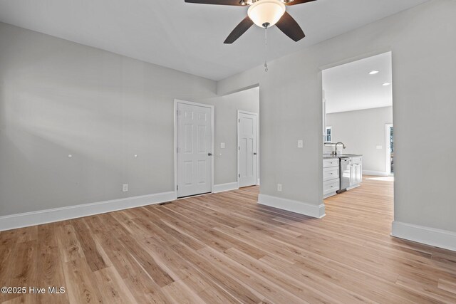 747 Warbler Pl, Vass, NC 28394 - interior space with light wood finished floors, a ceiling fan, baseboards, and a sink