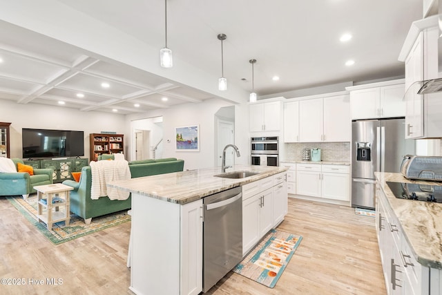 kitchen with coffered ceiling, open floor plan, appliances with stainless steel finishes, and a sink