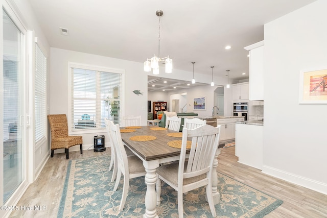 dining area featuring visible vents, baseboards, recessed lighting, light wood-style floors, and a notable chandelier