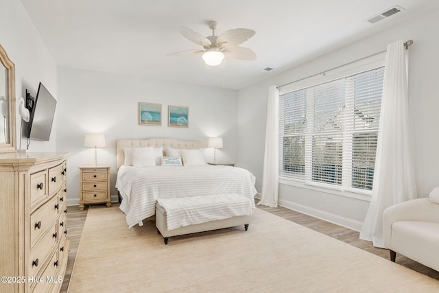 bedroom with visible vents, light wood-style flooring, baseboards, and ceiling fan