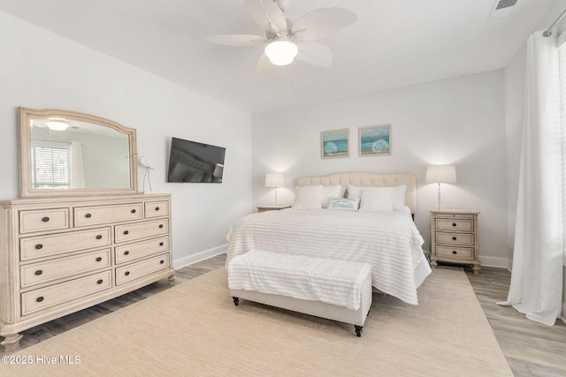 bedroom with wood finished floors, baseboards, and ceiling fan