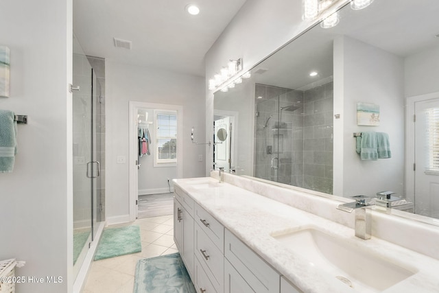 bathroom featuring a shower stall, visible vents, tile patterned floors, and a sink