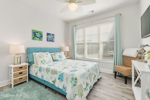 bedroom with visible vents, baseboards, wood finished floors, and a ceiling fan