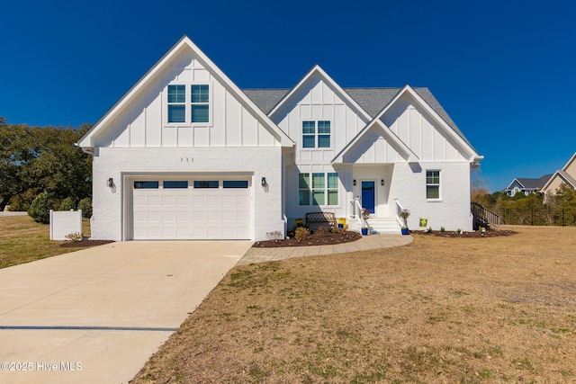 modern farmhouse with a front yard, a garage, board and batten siding, and driveway