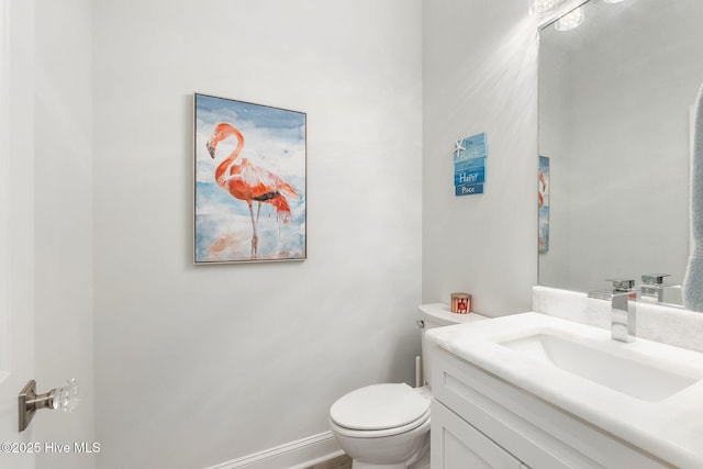 bathroom featuring vanity, toilet, and baseboards