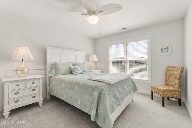 bedroom featuring visible vents, light carpet, baseboards, and ceiling fan