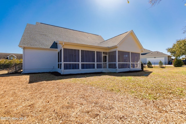 back of house with a yard, fence, a sunroom, and roof with shingles