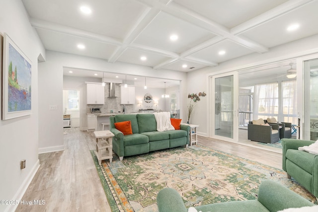 living room featuring beamed ceiling, coffered ceiling, light wood-type flooring, and baseboards