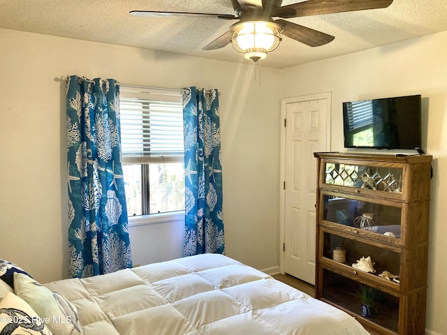 bedroom featuring a textured ceiling and a ceiling fan