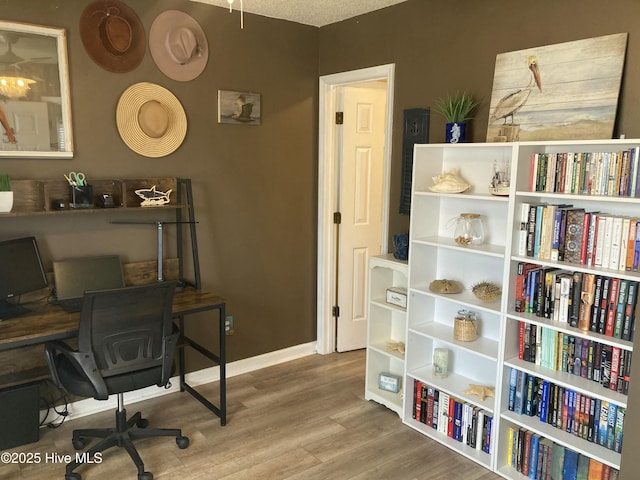 office space with baseboards and wood finished floors