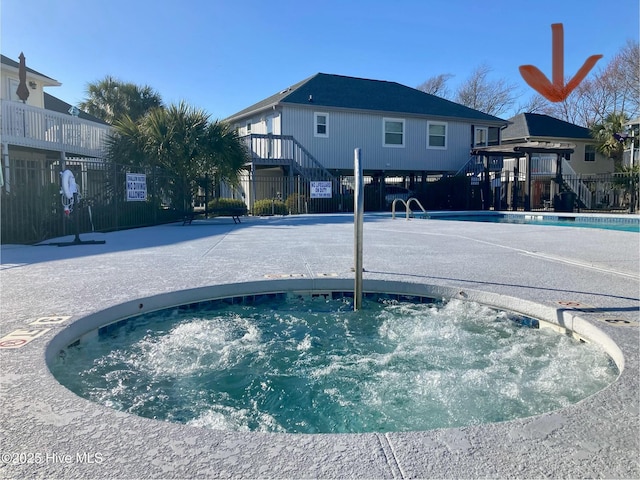 view of pool featuring fence and a hot tub