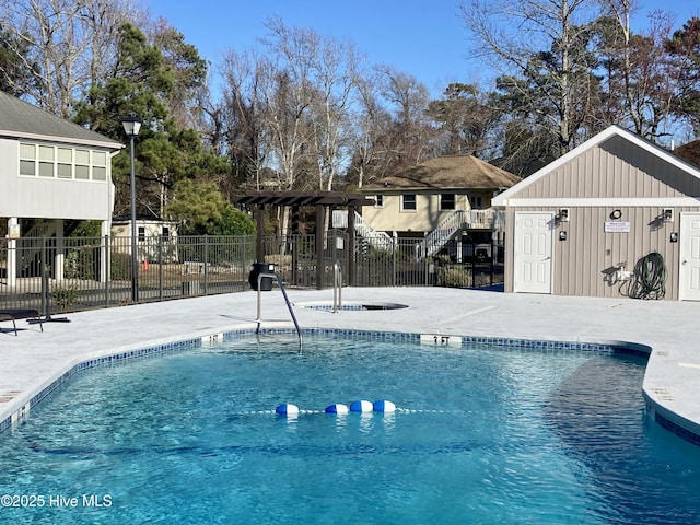 community pool with a patio area and fence