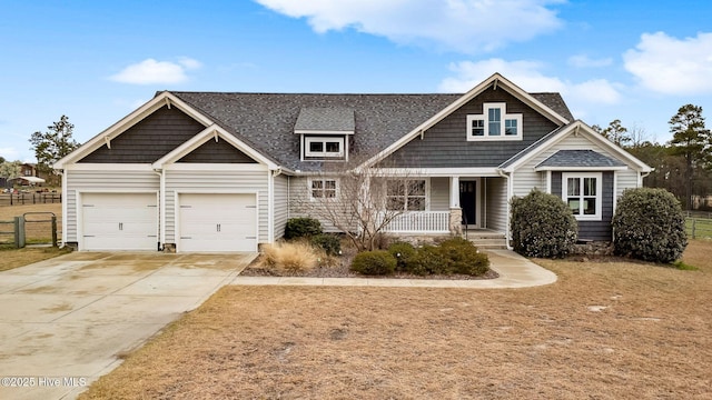 view of front of home featuring fence, roof with shingles, a porch, concrete driveway, and a garage