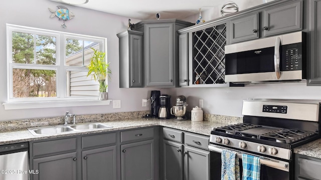 kitchen featuring a sink, stainless steel appliances, and gray cabinetry