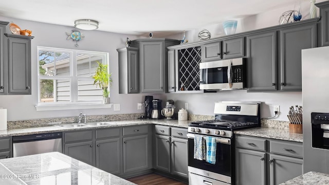 kitchen with a sink, stainless steel appliances, and gray cabinets