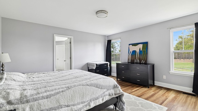 bedroom featuring visible vents, baseboards, and light wood-style flooring