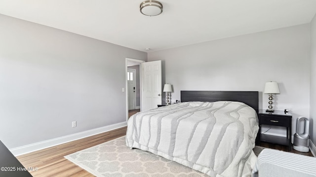 bedroom with baseboards and wood finished floors