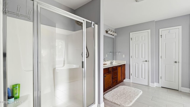 bathroom featuring a stall shower, vanity, and baseboards